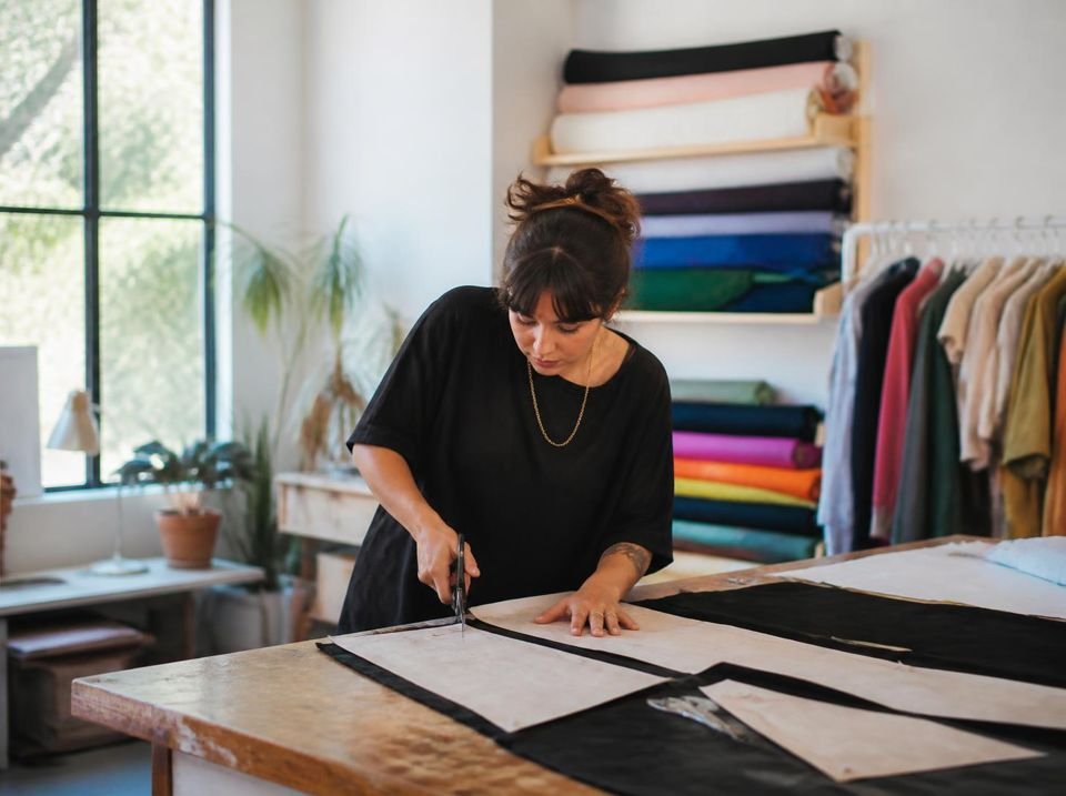 Diseñadora cortando tela en un taller textil